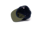 Two baseball caps, one green and one navy, on a white background